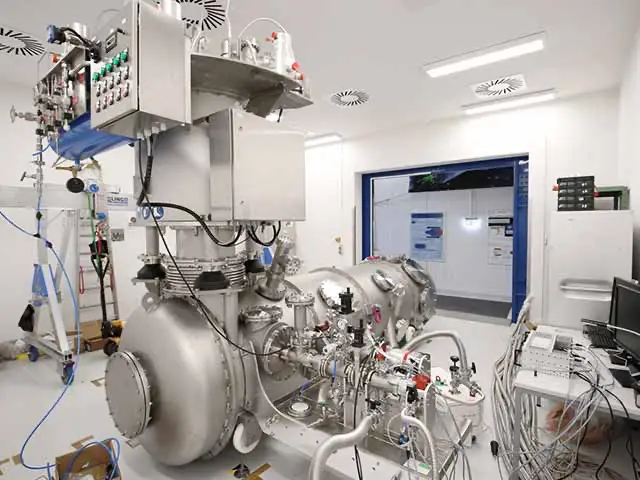 Scientific instrument with cooling tank fills a laboratory from floor to ceiling and transmits measurement data to a computer.