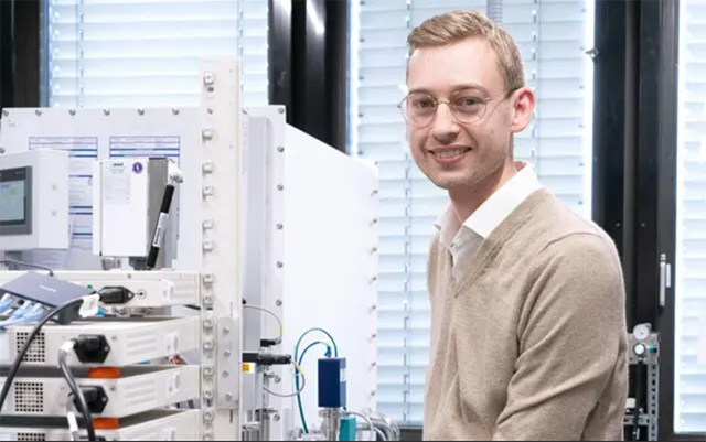 Fabian Apfelbeck working on a complex measurement device in the lab, wearing gloves and glasses.
