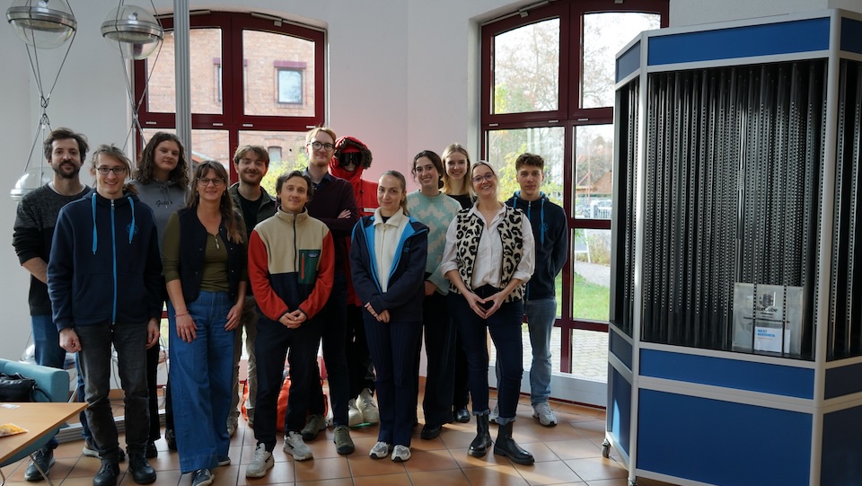 Eine Gruppe junger Leute schaut fröhlich und stolz in die Kamera.