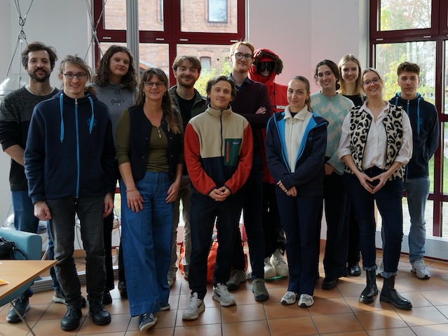 Eine Gruppe junger Leute schaut fröhlich und stolz in die Kamera.