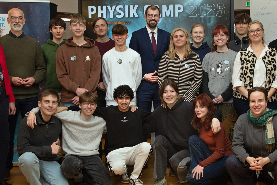 Gruppenbild mit ausgelassenen Jugendlichen mit Minister Freiberg und DESY-Direktor Stegmann.