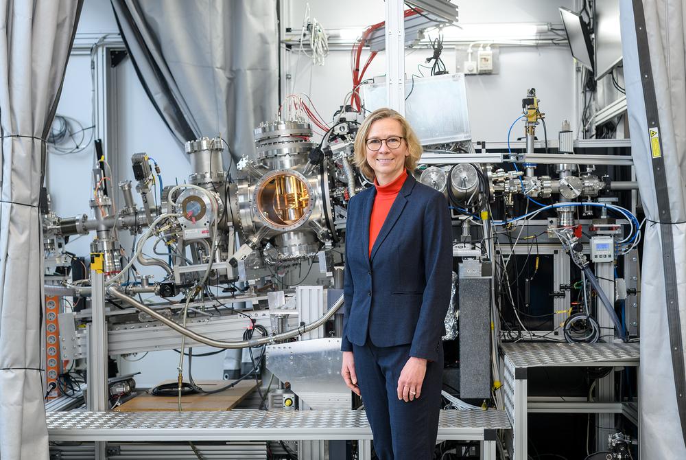 Photo of chemist and professor of experimental physics Britta Redlich in front of a research facility