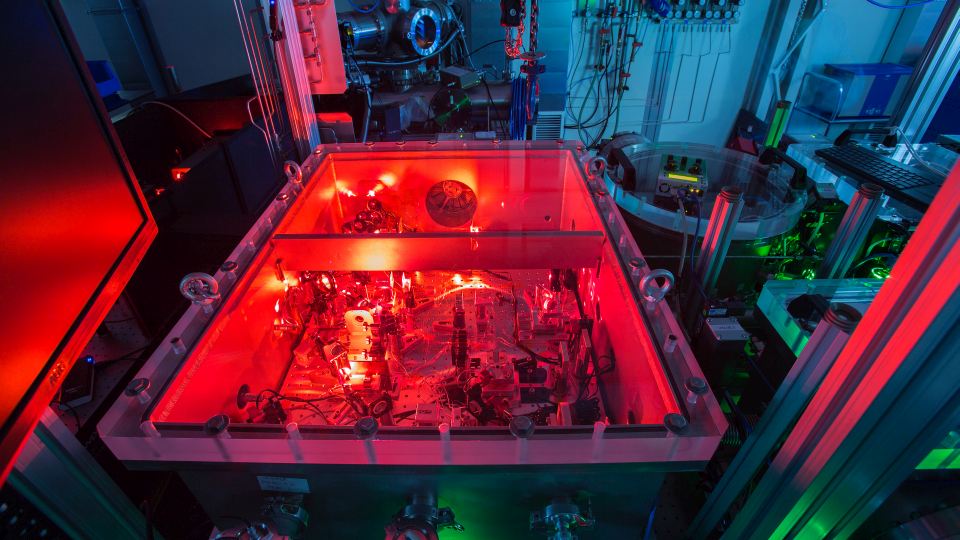 Scientific laser setup with red and green light sources in a high-tech laboratory.