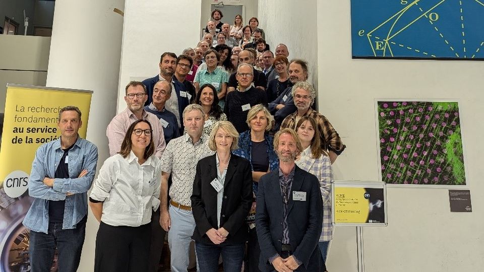 Gruppe von Wissenschaftler:innen auf einer Treppe bei einer Veranstaltung im CNRS-Gebäude.