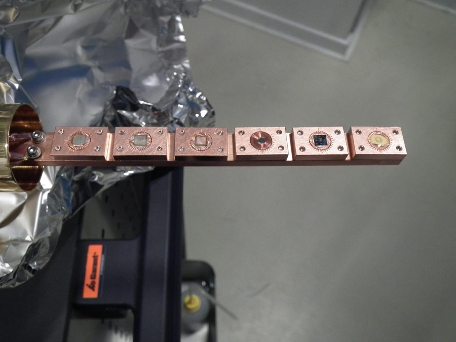 The samples with the tiny vanadium dioxide squares are mounted on this holder.