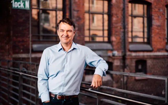 Jens Schröder in a portrait taken outside a brick building with an industrial look.