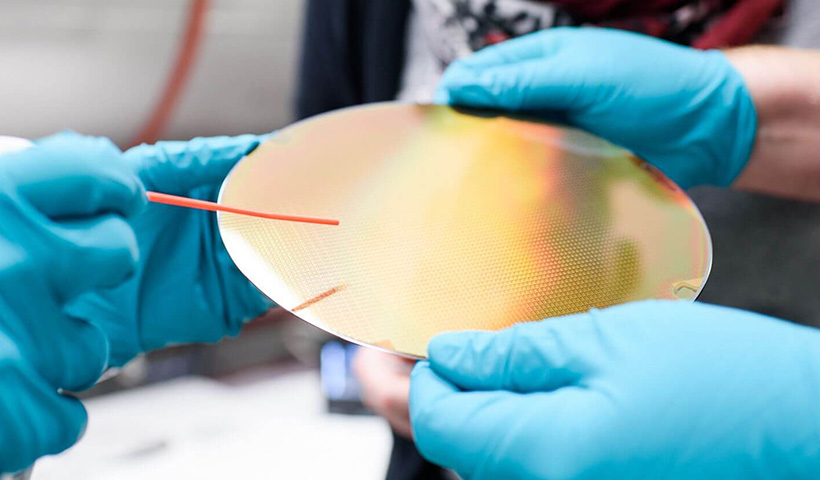 People holding a wafer.